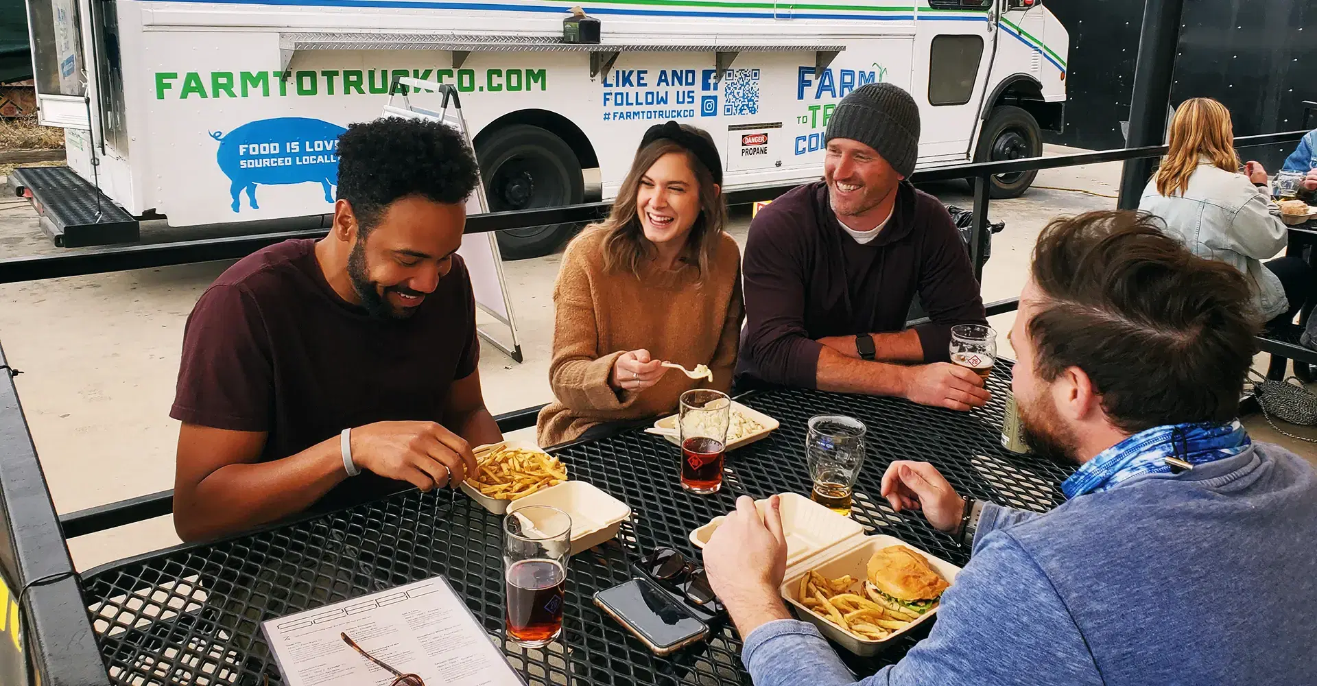 Friends together eating from a food truck at a brewery